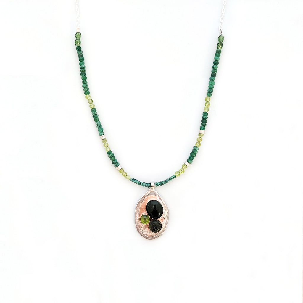 Handmade, one of a kind necklace, textured copper oval with sterling silver edge as backdrop for bezel-set natural green adventurine, peridot and dark green quartz, suspended from petite peridot and emerald beads