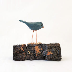 Hand-fabricated copper birdie with a soft blue gray enamel on cottonwood bark.