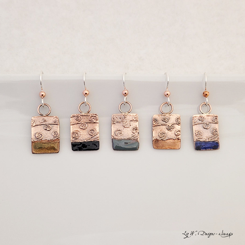 Handmade earrings. Hand-fabricated copper rectangle, etched with swirl design, bottom with dark navy enamel work