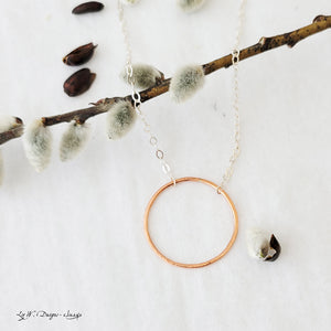 Hand-fabricated necklace with delicate copper circle connected with sterling silver chain