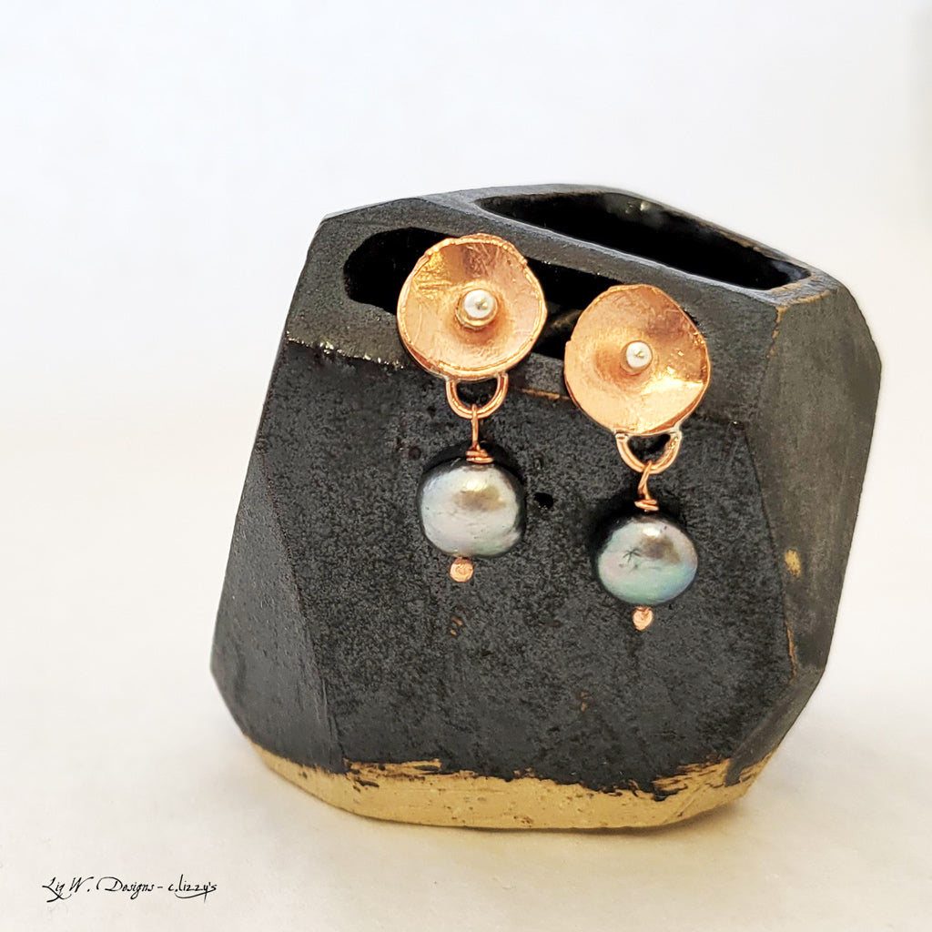 Hand-formed earring with textured copper flower with sterling silver center and darker freshwater pearl drop.