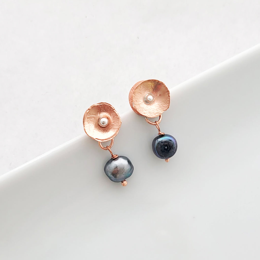 Hand-formed earring with textured copper flower with sterling silver center and darker freshwater pearl drop.