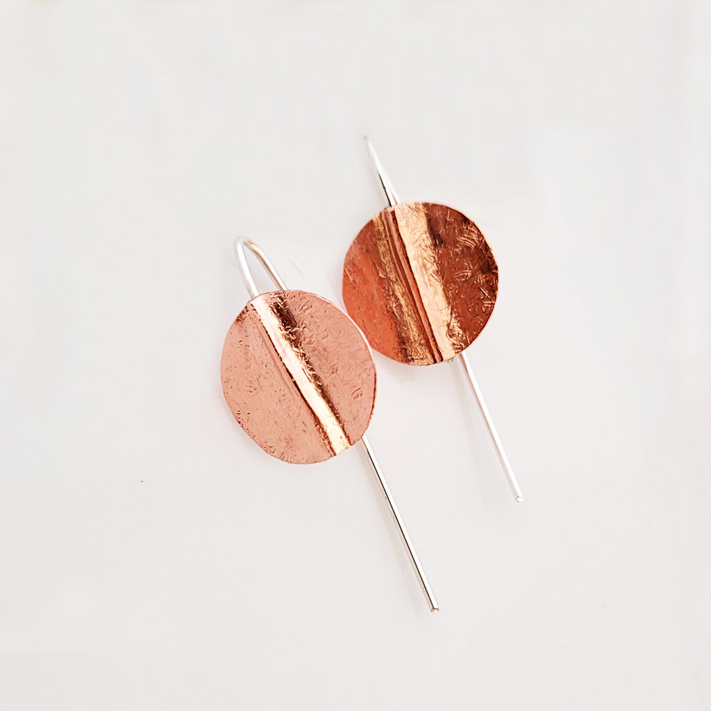 Handmade earrings, textured copper circle with stylized fold to add depth, with slip through design so back sterling wire shows behind the earlobe