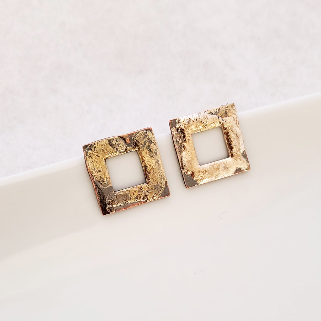 Handmade earrings, textured open copper squares with abstract sterling silver overlay that has hints of gold-tones