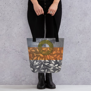 Tote bag of original art.  Avocado green circle on gray and light burnt orange background with off-white leaf design.